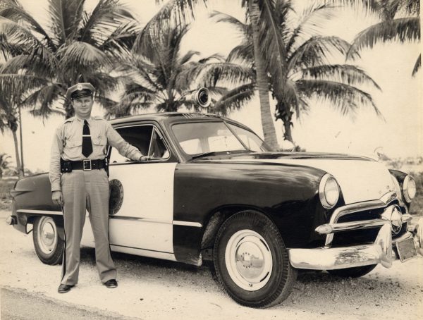 A Florida Highway Patrol Officer and his car in Key West C 1950. Monroe County Library Collection.